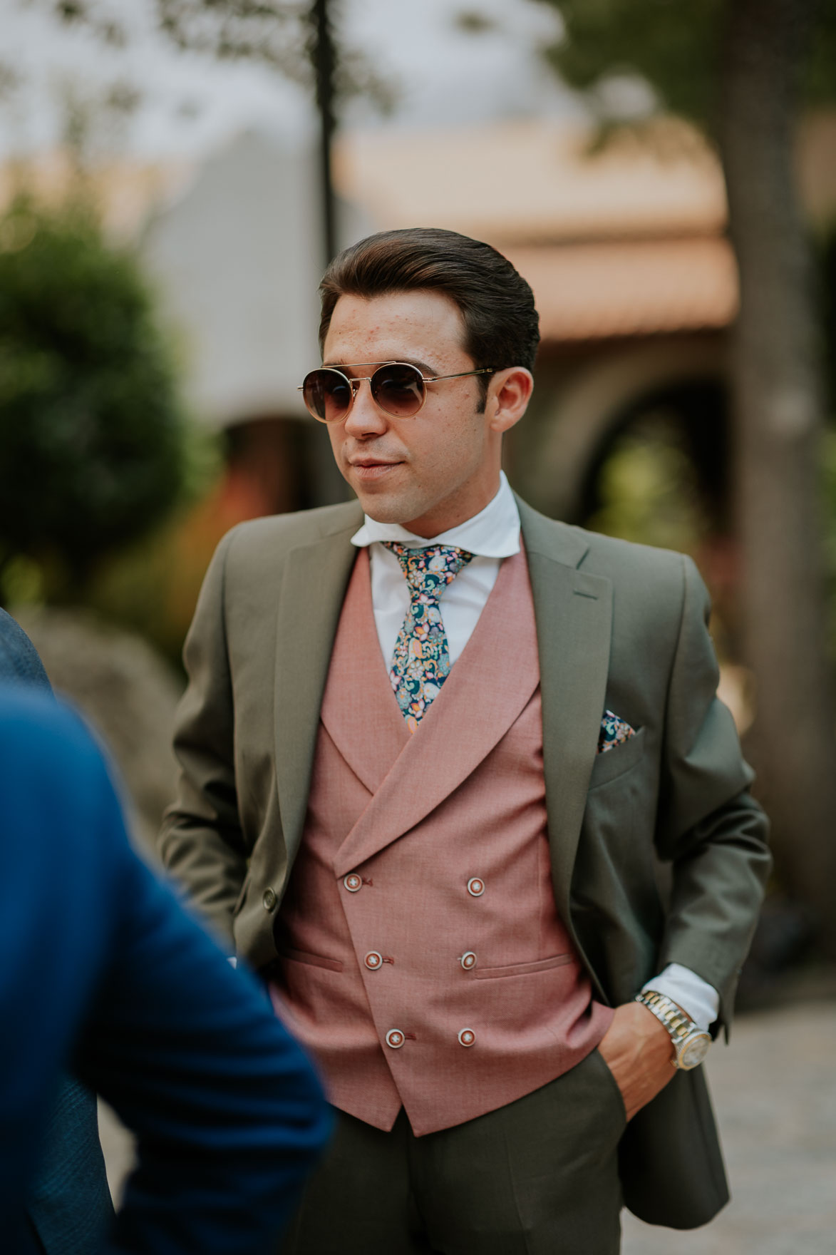 Invitado con traje verde y chaleco rosa